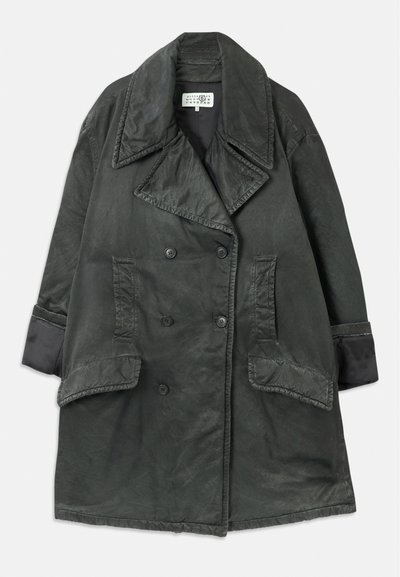 Σκούρο γκρι παλτό διπλής σειράς με φαρδιές πέτες, δύο μεγάλες τσέπες με καπάκι, τσέπες από το πλάι και λεπτομέρειες στους μανικιών σε απλό φόντο.