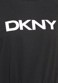 Tissu noir avec grand logo blanc DKNY imprimé au centre.