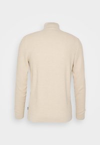 Beige långärmad tröja med ribbad textur och ståkrage. Platt nederkant och åtsittande mudd. Inga synliga logotyper eller mönster. Endast sett bakifrån.