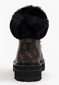 Botte en fausse fourrure noire avec cuir marron à motifs. Semelle noire épaisse, détails en métal doré et motif logo distinctif sur l'extérieur.