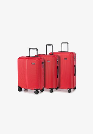 Trois valises rigides rouges de tailles variées avec des rainures verticales, des poignées noires et des roulettes pour la mobilité. Chacune d'elles est équipée d'un mécanisme de verrouillage.