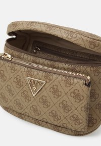 Borsa in tessuto marrone con texture, accessori in oro e un logo triangolare. Dotata di un scomparto principale con zip e di una tasca esterna con zip.