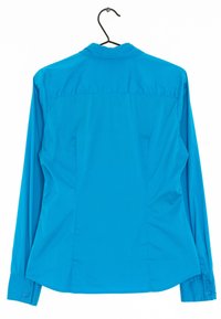 Helles blaues langärmliges Hemd mit Knopfleiste, das an einem schwarzen Kleiderbügel hängt. Die Rückansicht zeigt die sichtbaren Nähte und Manschetten.