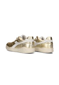 Gouden en witte sneakers met een metallic afwerking, vetersluiting, gewatteerde kraag en een rubberen zool met textuur en logodetail.