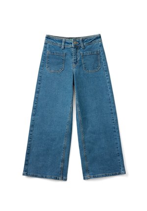 Jeans de mezclilla azul de pierna ancha con bolsillos delanteros de parche, trabillas para cinturón y cierre de botón sobre fondo blanco.