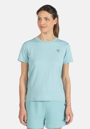 T-shirt bleu clair à col rond en tissu doux, à manches courtes, avec un petit logo sur la poitrine et une coupe décontractée, associé à un short assorti.