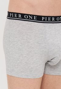 Boxeri gri din bumbac cu talie neagră, având inscripție albă "PIER ONE." Textură netedă, ajustare confortabilă, cusături bine realizate.