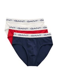 Drei Paare Herrenunterhosen in Marineblau, Weiß und Rot. Jede verfügt über einen weichen Bund mit "GANT"-Logo und einem klassischen Unterhosen-Design.