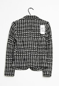 Svart och vit rutig kavaj med en strukturerad tyg, enkel notch slag och etikett fäst. Har en rundad nederkant och långa ärmar.