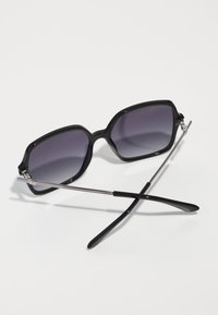 Ochelari de soare negri, de dimensiuni mari, cu lentile întunecate în degrade, formă rectangulară, cadru gros din plastic și accente metalice argintii pe balamale.