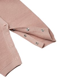 Jasnoróżowy sweter typu cardigan z teksturowanym, dzianym wzorem, z zatrzaskami na rękawach i ściągaczami na mankietach dla dodatkowego detalu.