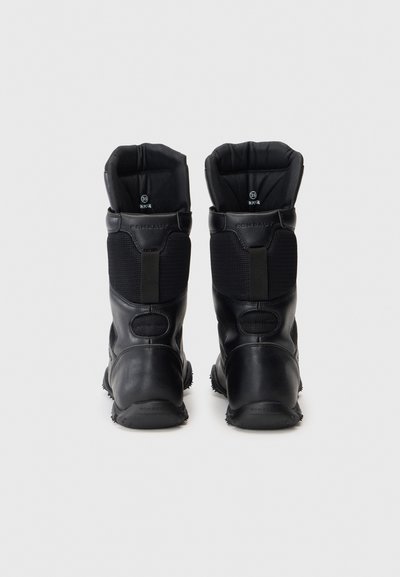 Des bottes noires imperméables présentent un extérieur en cuir texturé, des poignets rembourrés et des inserts élastiques pour un ajustement parfait. Des semelles en caoutchouc durables offrent une bonne traction.