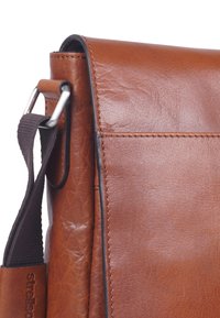 Borsa messenger in pelle marrone con finitura testurizzata, dotata di patta ribaltabile, tracolla regolabile e dettagli in metallo.