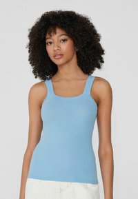 Hellblaues Ripp-Tanktop mit breiten Schulterträgern und quadratischem Ausschnitt, das eine enganliegende Passform und eine glatte Textur aufweist.