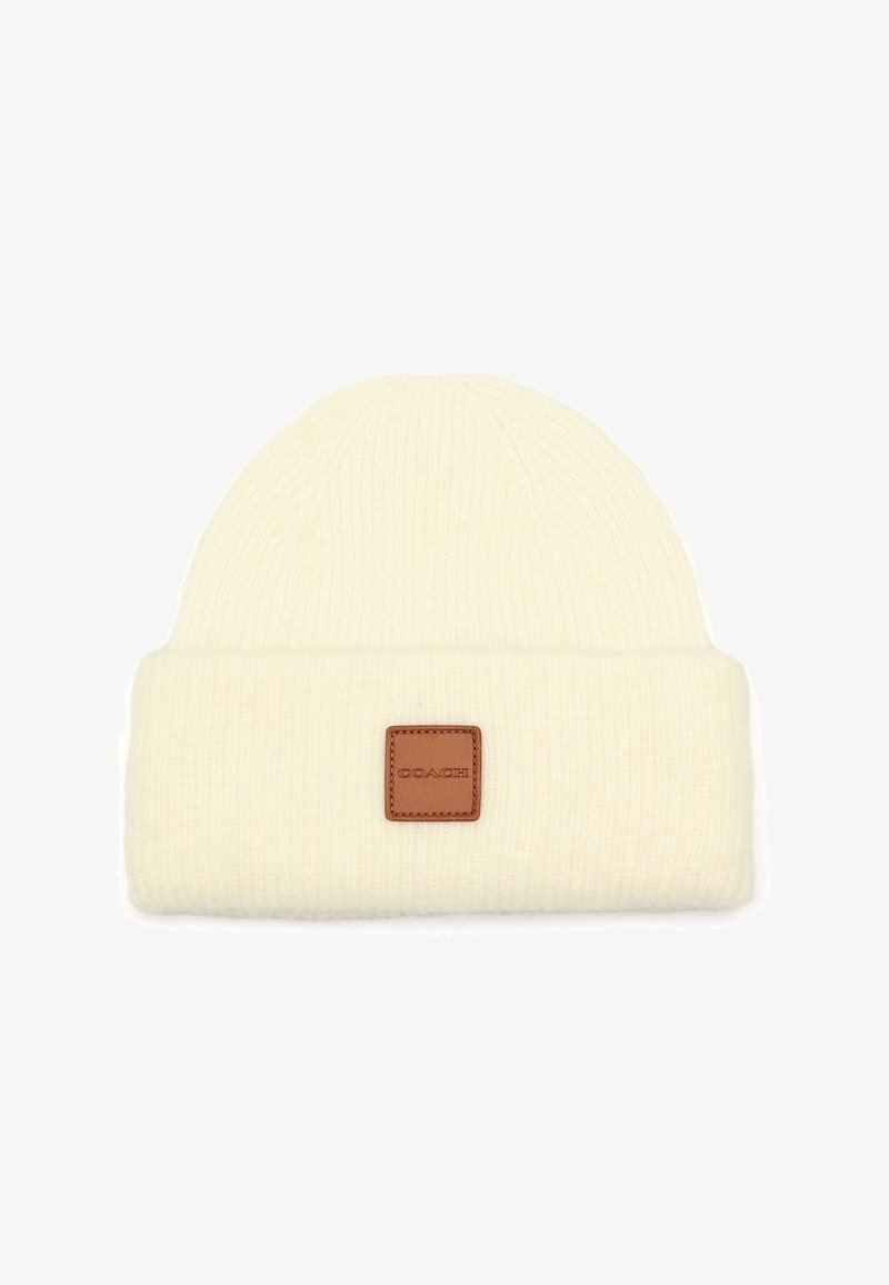 Crème gebreide beanie met een omgeslagen rand, voorzien van een vierkante leren patchlabel aan de voorkant. Gecoat, rekbaar stof.