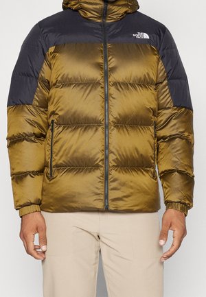 Groene en zwarte gewatteerde jas met rits aan de voorkant, met ritssluitingen aan de zijkanten, elastische manchetten en het The North Face-logo op de borst.