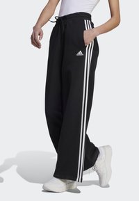 adidas Sportswear - ESSENTIALS STRIPES WIDE PANT - Tracksuit bottoms - black/white Thumbnail Image 1