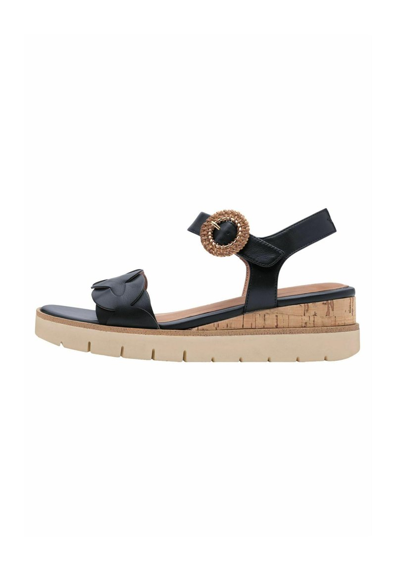 Zwarte leren sandaal met een strikdetail en een gestructureerde, geweven ronde gesp. Kurkachtige wigzool met een contrasterend beige platform.