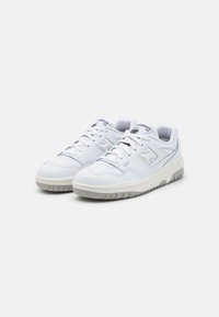 Weiße Sportschuhe mit einem glatten Lederoberteil, kontrastierenden grauen Akzenten, Schnürdesign und strukturierten Gummisohlen für besseren Halt.
