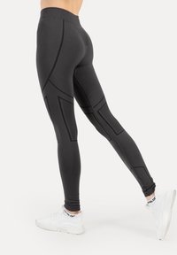 Sorte atletikleggings med teksturerede paneler, der har en høj talje og geometriske accenter langs benene. Glat stoffinish.