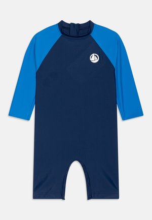 Marineblauwe wetsuit met korte mouwen en een ronde hals, een rits aan de achterkant en drukknoopsluitingen onderaan. Bevat een zeilbootlogo.