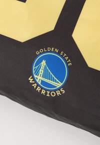 Tessuto nero con design geometrico giallo e nero che presenta il testo "GOLDEN STATE WARRIORS" e un logo blu di un ponte all'interno di un cerchio.