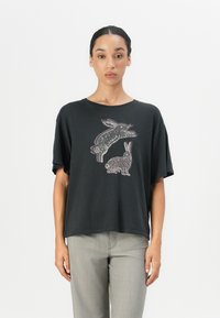 Black cotton t-shirt with a relaxed fit and short sleeves, featuring a colorful graphic of two rabbits on the front.