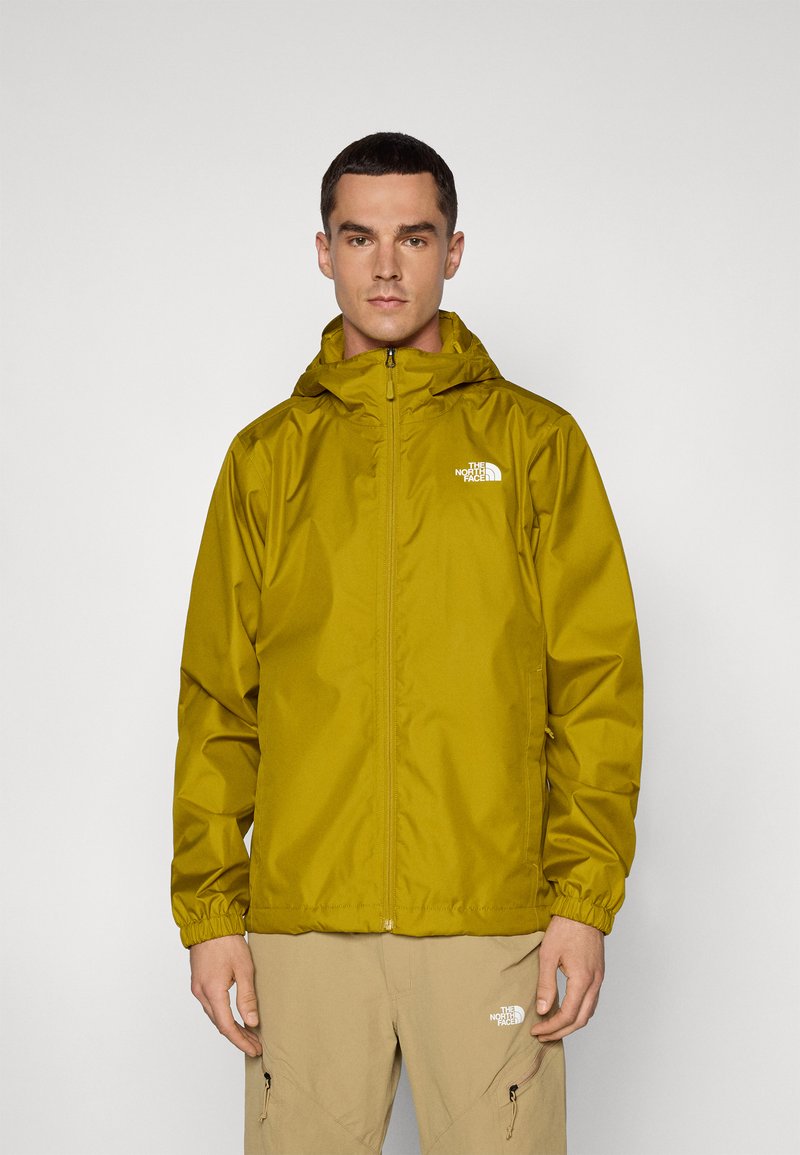 Veste étanche jaune avec fermeture éclair à l'avant et capuche ajustable. Équipée de poignets élastiques et d'un logo sur la poitrine gauche. Matière lisse et légère.