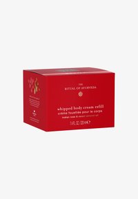 Scatola rossa per il rifornimento di crema per il corpo montata, con etichetta contenente nome del prodotto, dettagli sulla fragranza e volume. Superficie testurizzata con accenti floreali.