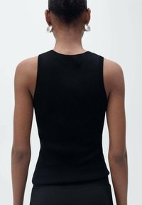 Black ribbed sleeveless top with a fitted design, displaying a high neckline and subtle texture. No visible patterns or accents.