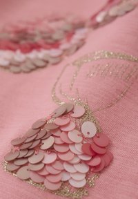 Rosa Stoff mit mehrschichtigem Pailletten-Design in Rosatönen und Beigetönen, mit goldenen Glitzereffekten und einer glatten Textur.