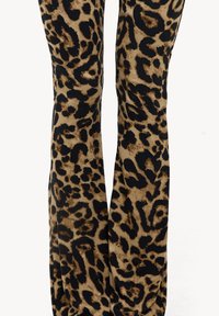 Pantalones acampanados de estampado de leopardo en una textura suave y aterciopelada. Presentan una mezcla de patrones marrones y negros sobre un fondo beige.