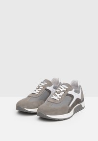 Sneaker in suede grigio e mesh con dettagli bianchi. Le caratteristiche includono chiusura con lacci, colletto imbottito e suola testurizzata per migliorare la presa.