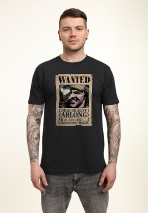 Black cotton t-shirt featuring a wanted poster graphic with bold "WANTED" text and a character portrait. Short sleeves and relaxed fit.