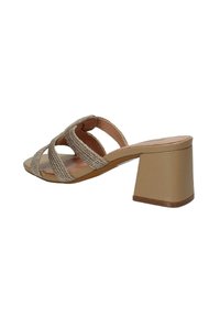 Sandalo beige con tacco alto, con fasce intrecciate, design con punta aperta e tacco quadrato. Texture liscia con una leggera lucentezza.