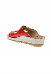 Sandalia deslizante roja de charol con diseño recortado, plantilla acolchada, suela de cuña blanca y suela de goma texturizada.