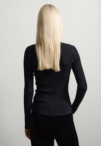Zwarte geribde lange mouwtop, aansluitend ontwerp met textuurstof. Heeft een ronde halslijn en een gladde afwerking, gezien vanaf de achterkant.