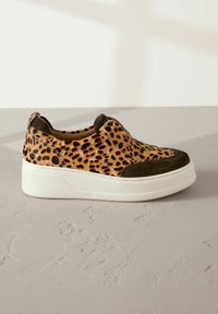 Leopard-print slip-on shoes with a textured upper and dark green suede accents, featuring a white sole with a slight platform.