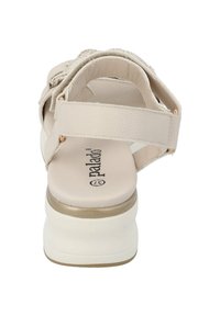 Sandalo beige con tomaia in pelle testurizzata, design con cinturini, supporto alla caviglia e suola piatta bianca. Logo stampato sulla soletta.