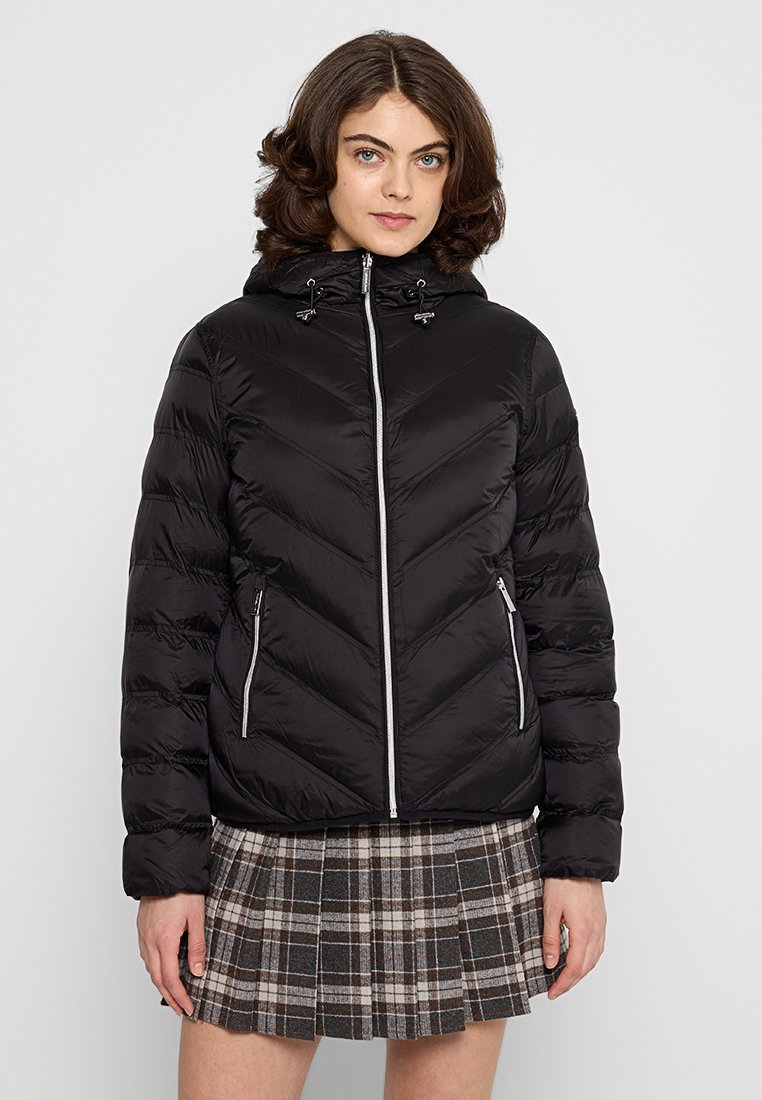 Veste en duvet noire avec un design matelassé en chevrons, deux poches zippées à l'avant, une capuche avec cordon de serrage et des accents en zipper argenté.