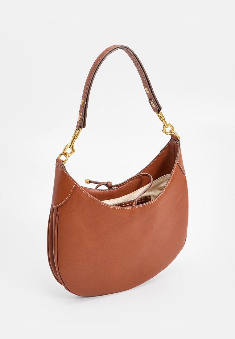 Braune Lederhandtasche mit geschwungener Form und einem abnehmbaren braunen Riemen, ausgestattet mit goldenen Beschlägen und einem beigen Innenfutter.
