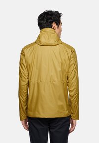 Yellow lightweight jacket with a hood, featuring a smooth texture and elastic waist. Shown from the back, highlighting seam details.