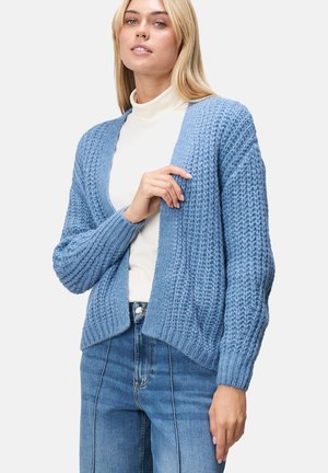 Lichtblauwe gebreide cardigan met een losse pasvorm, geribde structuur en een open voorkant. Draag het over een witte coltrui en combineer het met denim.