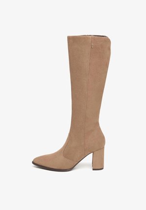 Botte en daim beige, arrivant au genou, avec un bout pointu et un talon carré. Présente des détails de couture le long des côtés. Texture douce et design élégant.
