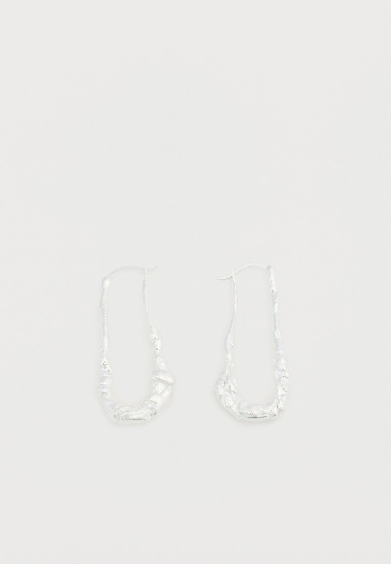 Boucles d'oreilles créoles en argent avec un design organique et texturé. Les boucles d'oreilles présentent une forme torsadée et des crochets fins en fil pour la fermeture.