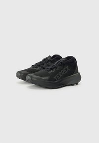 Czarne buty sportowe z siateczkową cholewką, teksturowanym bokiem, detalami logo i wytrzymałą podeszwą zapewniającą przyczepność. Posiadają system sznurowania oraz amortyzowaną podeszwę.
