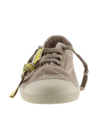 Sneaker in tela beige con punta in gomma, design con lacci e un'etichetta gialla. Presenta una suola testurizzata per aderenza e durabilità.
