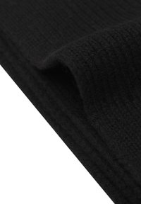 Tissu noir côtelé avec une texture douce, partiellement plié pour montrer des couches et de la profondeur, présentant une couleur uniforme sans motifs ni accents.