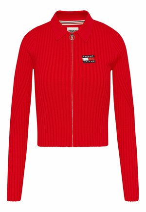 Rode geribbelde cropped cardigan met een kraag en een ritssluiting aan de voorkant. Voorzien van een klein zwart-wit "TOMMY JEANS" logo op de borst.