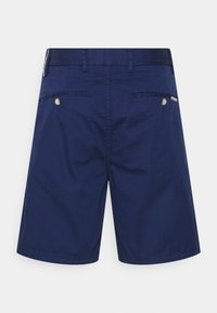 Marineblauwe shorts gemaakt van lichtgewicht stof, voorzien van twee achterzakken met knoopsluitingen en riemlussen. Soepele textuur met een moderne snit.